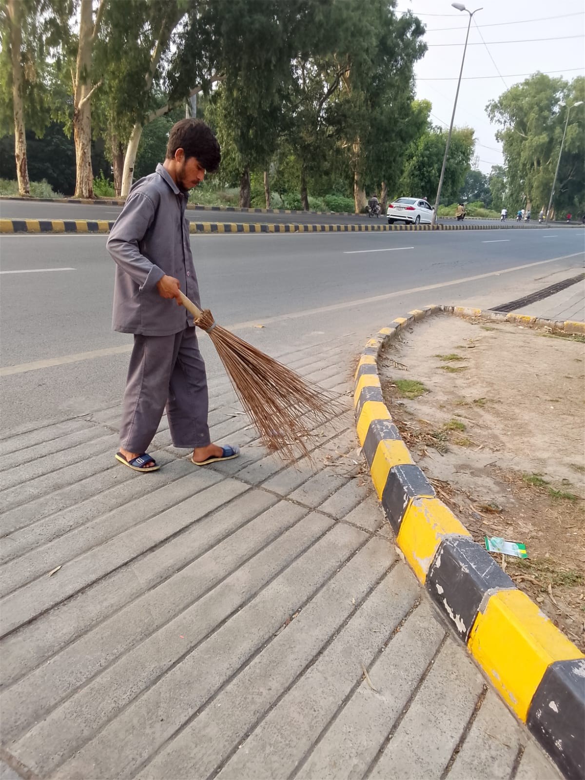 EHAS worker sweeping an external paved area